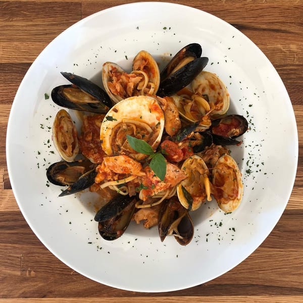Genaros Restaurant's linguine with clams and mussels in red sauce, garnished with basil.